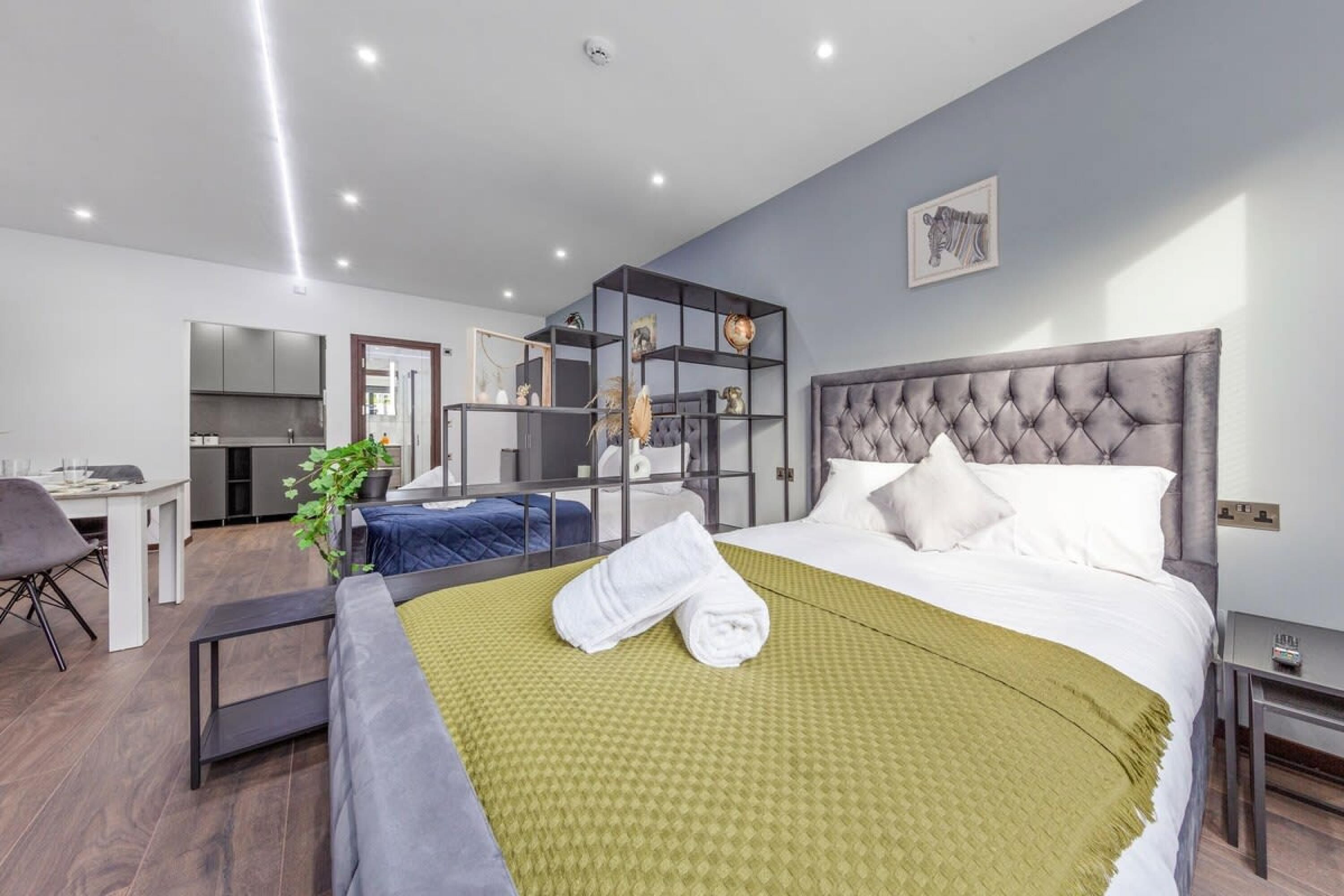 Une chambre d’hôtel moderne dotée d’un grand lit, d’un bureau et d’une kitchenette.