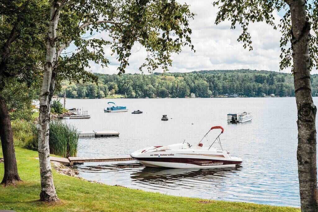 A lake with a dock and a boat named 'Islandia' anchored near the shore.