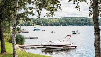 A lake with a dock and a boat named 'Islandia' anchored near the shore.
