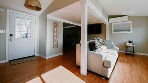 A living room with a white sofa, a woven light fixture, and a 'HOME' sign on the wall. - Little Landing Cottage-gorgeous View BBQ Wi-fi (Winthrop)