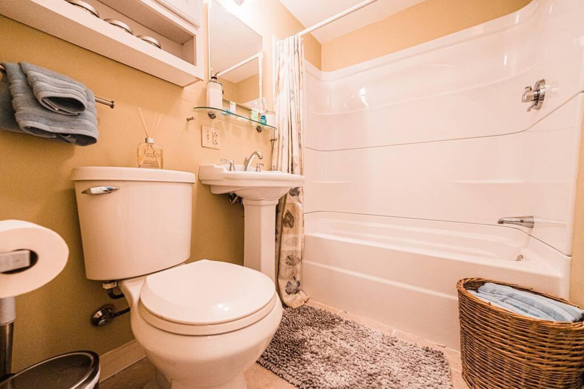 A bathroom with a toilet, sink, and bathtub.