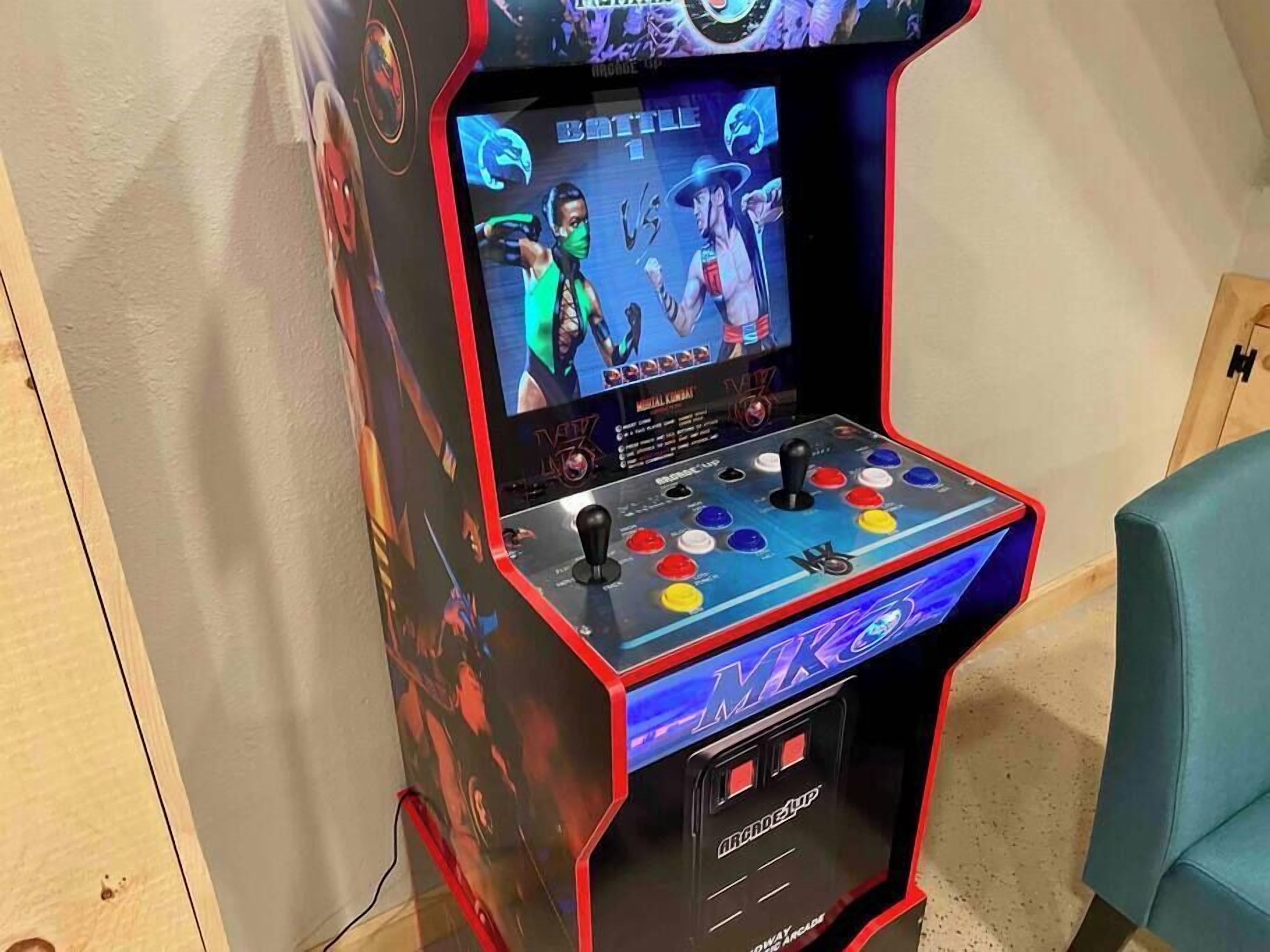 A gaming arcade machine with a joystick and colorful buttons, featuring a screen displaying a game.