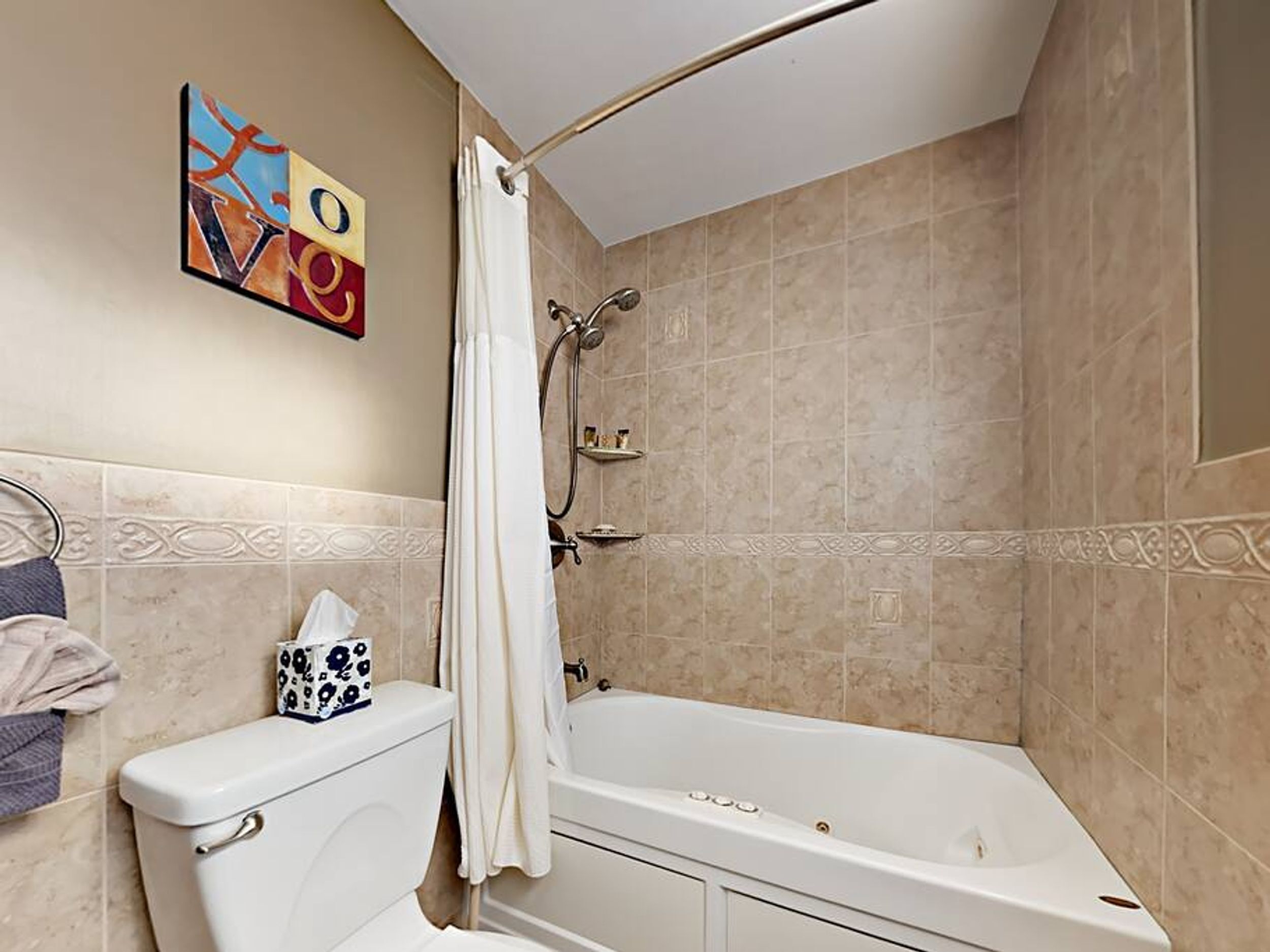 A bathroom with a bathtub, toilet, and shower.