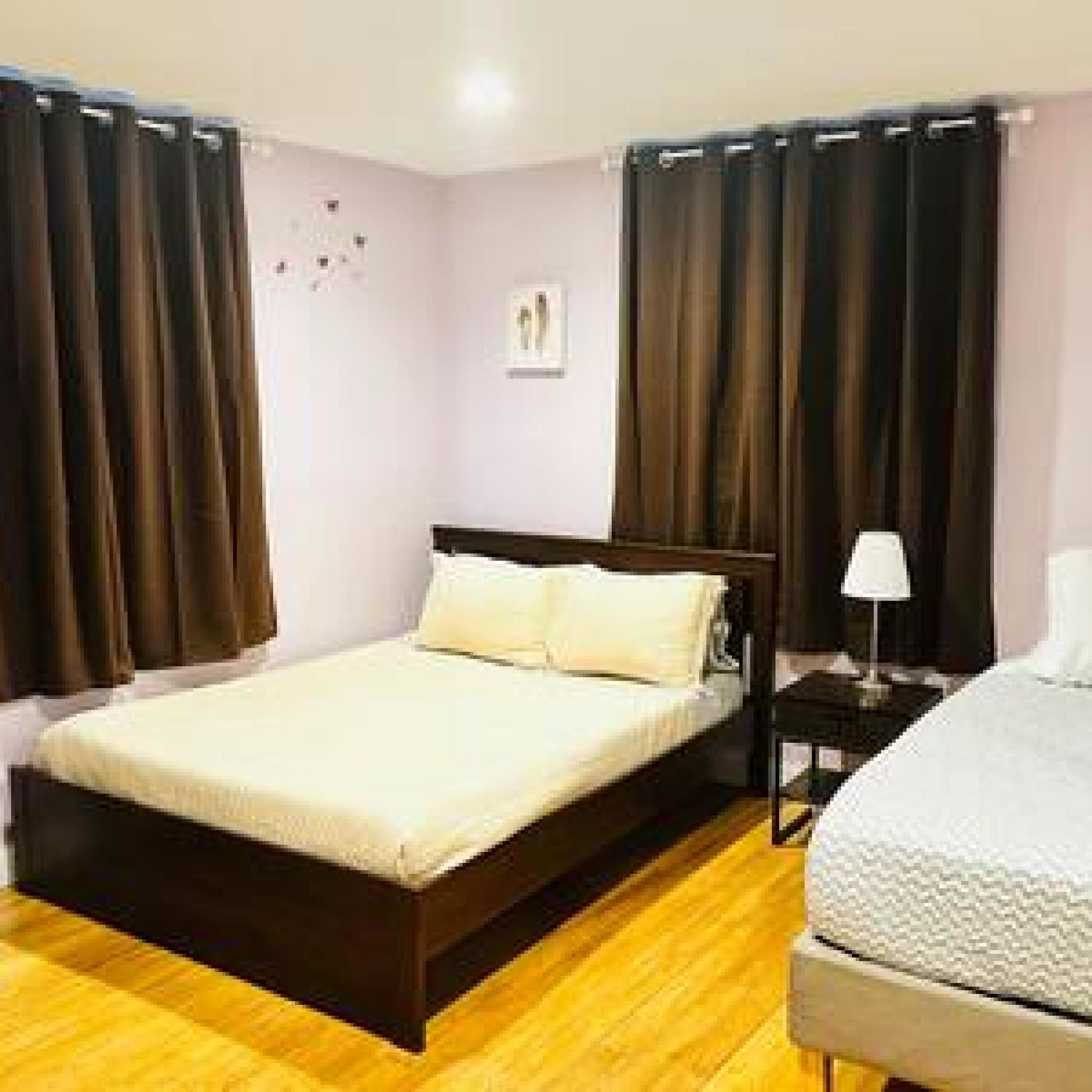 A bedroom with a bed, a nightstand, and a lamp.