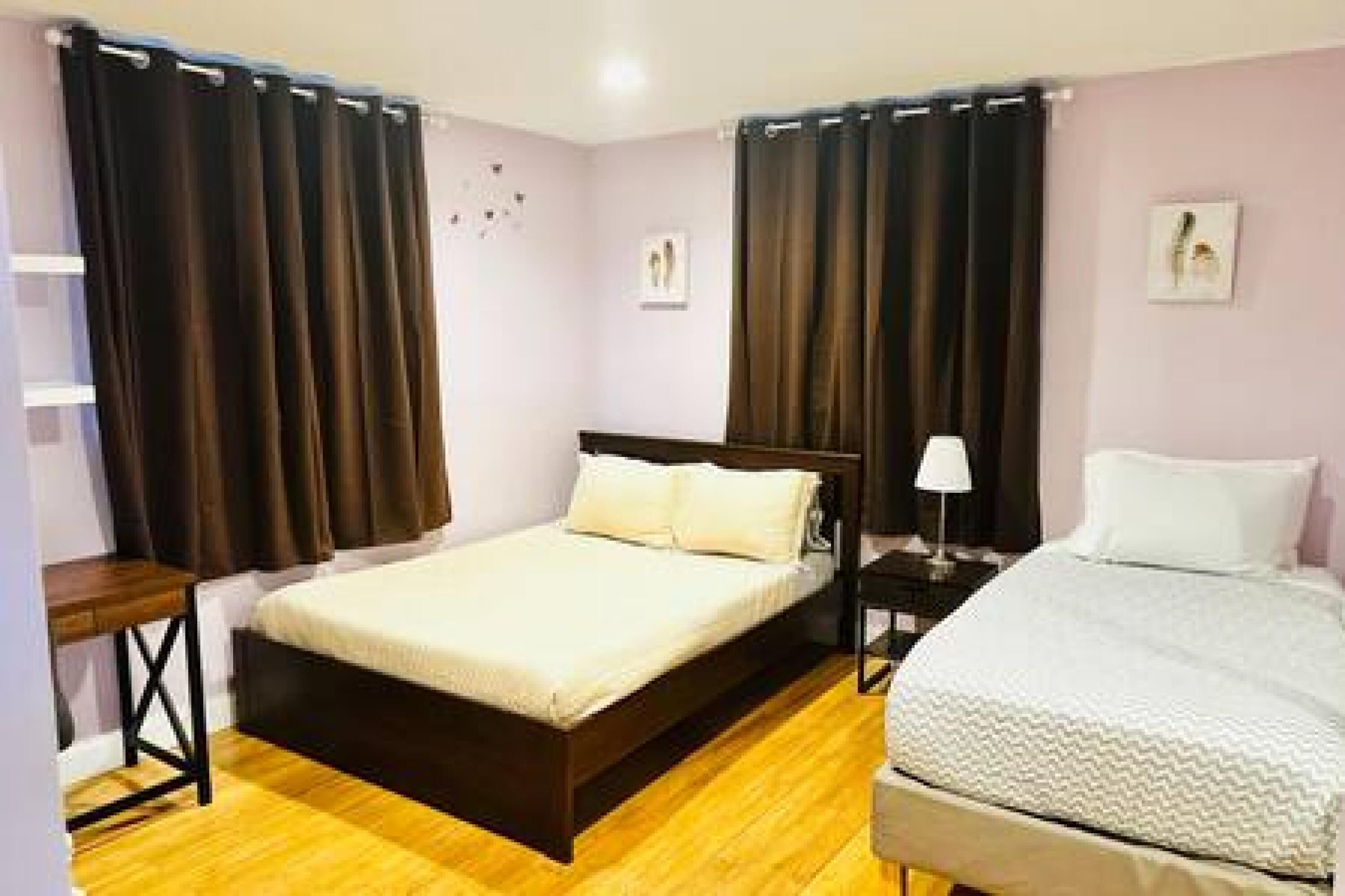 A bedroom with a bed, bedside tables, and curtains.