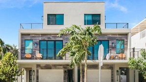 A modern two-story building with large windows and a balcony. - Luxury Paradise Walk to Las Olas -5 Mins to Beach (Fort Lauderdale)