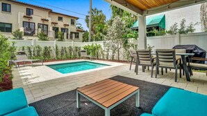 A covered outdoor patio with a pool, seating area, and a barbecue setup. - Luxury Paradise Walk to Las Olas -5 Mins to Beach (Fort Lauderdale)