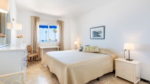A hotel room with a bed, bedside tables, a desk, and a chair. - Maritimo Rey | Beach Front Apartment in Fuengirola (Fuengirola)
