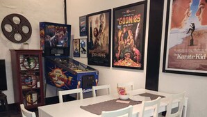 Un comedor con una mesa y sillas blancas, rodeado de carteles de películas en la pared.