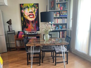 Cozy living space with a dining area, featuring a glass-top table and four comfortable chairs.