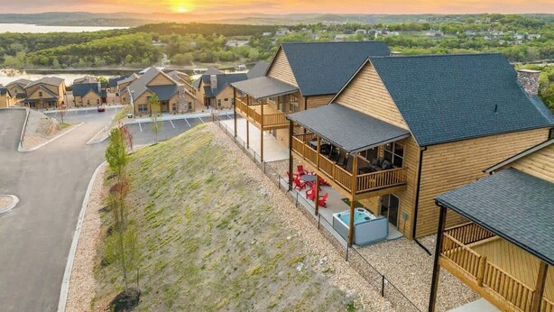A resort with multiple wooden cabins, a covered outdoor seating area, and a view of the surrounding landscape. - Sauna·Lake View·Hot Tub·Pickleball·Pools·Fire Pit (Branson)