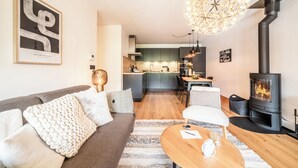 A modern living room with a sofa, coffee table, and a fireplace. - Opale - Cozy apartment with terrace in Megève (Megeve)
