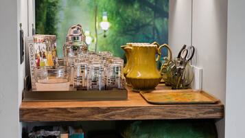 A kitchen counter with a coffee machine, a yellow pitcher, and a set of kitchen utensils.
