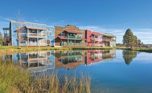 A row of colorful buildings by a calm lake with reflections. - WorldMark Bison Ranch - 1 Bedroom Accessible (Overgarrd)