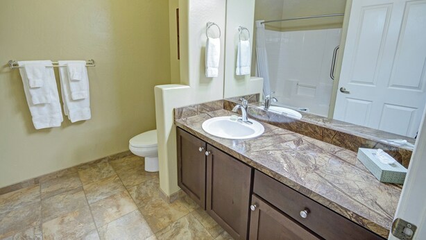 A bathroom with a marble sink, a toilet, and a mirror. - WorldMark Bison Ranch - 2 Bedroom (Overgarrd)
