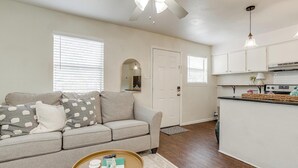 A living room with a sofa, coffee table, and a ceiling fan. - The Verde in the Fort! (Fort Worth)