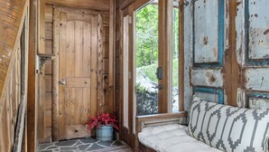 A wooden interior with a bench, a door, and a window. - Fox & Bear Lodge Near Center Hill Lake (Smithville)