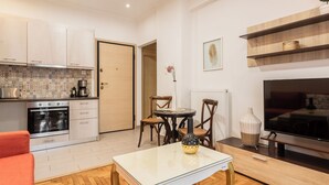 Una cocina moderna con comedor, televisor y una pequeña mesa con sillas.