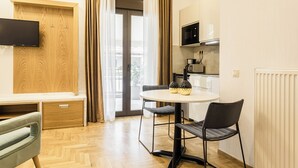 Una cocina moderna con microondas, estufa y comedor con mesa y sillas.
