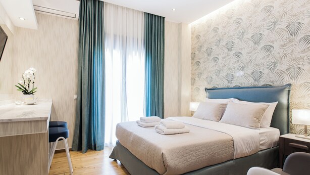 A modern hotel room with a bed, bedside table, and a desk with a chair. - Romantic Studio in the Heart of Athens (ATHENS)