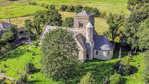 A church with a prominent tower, surrounded by green fields and scattered trees. - 5 bedroom accommodation in Rossendale (Rossendale)
