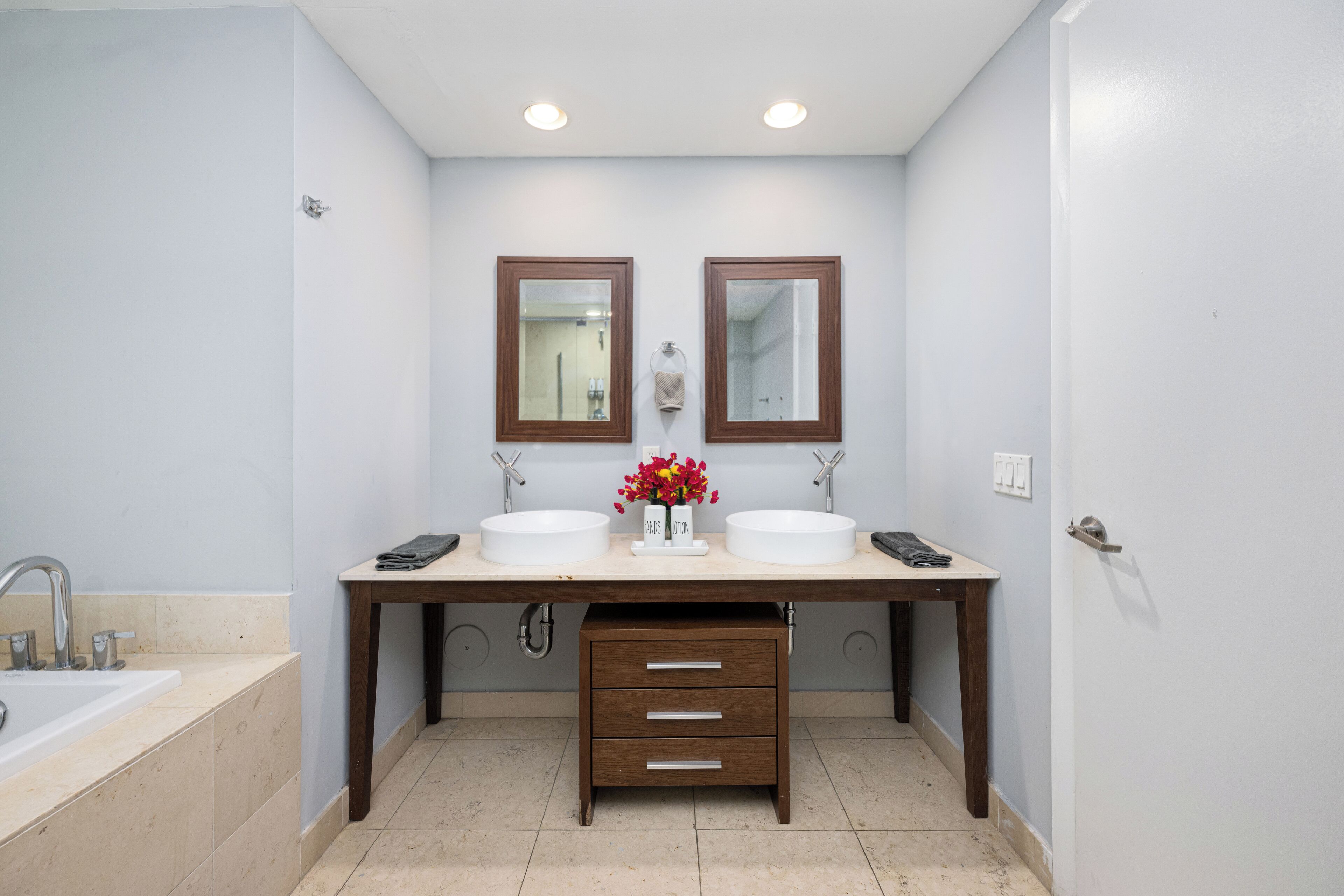 A bathroom with two sinks, a vanity, and a mirror.