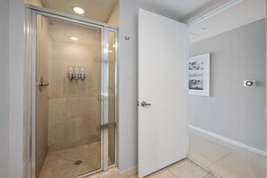A modern bathroom with a glass shower enclosure, a white door, and a framed picture on the wall. - Icon Brickell Miami Condos (Miami)