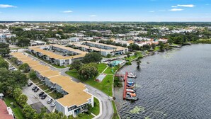 Zona residencial con edificios de apartamentos modernos, una piscina y un muelle con barcos.