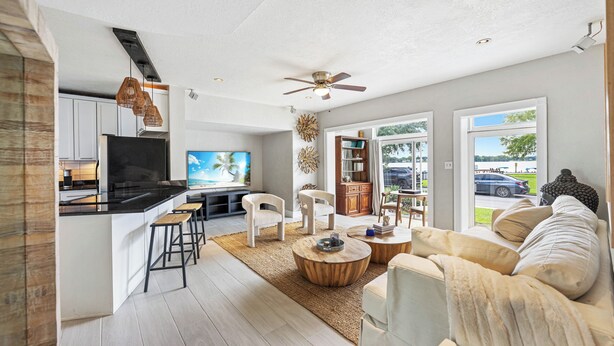Un espacio de sala-comedor moderno y abierto con cocina, zona de comedor y un gran ventanal con vistas al exterior.