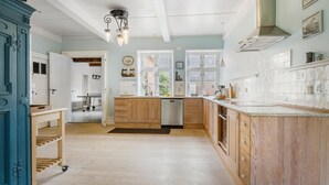 A spacious kitchen with wooden cabinets, a dishwasher, and a large window. - Gorgeous home in Bredebro with WiFi (Bredebro)