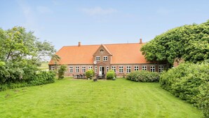 A large, two-story brick building with a red-tiled roof, surrounded by a well-maintained lawn and dense greenery. - Gorgeous home in Bredebro with WiFi (Bredebro)