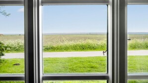 A view through a window of a field, a path, and a distant horizon. - Gorgeous home in Bredebro with WiFi (Bredebro)