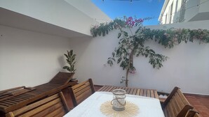 An outdoor patio with a wooden table and benches, a white tablecloth, and a potted plant. - Casa Sonia Great location Quiet area Easy access (Óbidos)