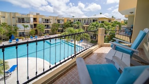 Un hôtel doté d’une piscine, de chaises longues et offrant une vue sur d’autres immeubles d’hôtels.