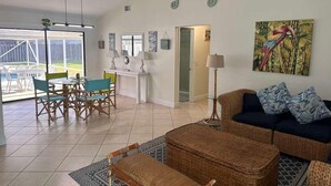 A spacious living area with a dining set, a sofa, and a painting. - Port St Lucie 3BD -2B (Port Saint Lucie)