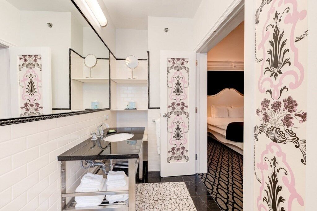 A modern bathroom with a vanity, sink, and towel rack.