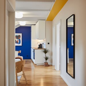 A modern kitchen with white cabinets, a wooden countertop, and a small potted plant. - Tkalčićeva 82/1 (Zagreb)