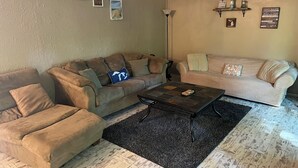 Ein Wohnzimmer mit zwei Sofas, einem Couchtisch und einem Teppich.