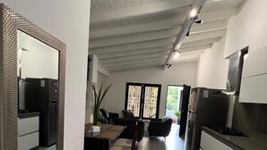 Une cuisine moderne avec un coin repas, comprenant un grand miroir, une table à manger avec des chaises et un îlot de cuisine.