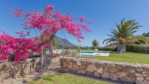 A stone wall, a pool, and a clear blue sky. - Terraced house with swimming pool (Tertenia)