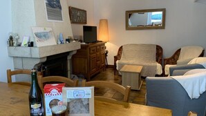 Ein gemütliches Wohnzimmer mit Kamin, Holzmöbeln und Fernseher.