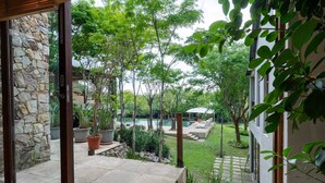 Un muro de piedra, una piscina y un patio con plantas en macetas y una zona de estar.