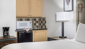 A compact hotel room with a bed, a small kitchenette with a microwave, a sink, and a coffee maker. - Scottsdale | Relaxing Desert Retreat | Pool + Hot Tub (Scottsdale)