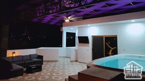 Terraza en la azotea con piscina, zona de estar y techo decorativo.