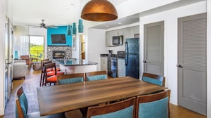 A modern kitchen with a central island, built-in appliances, and a dining area with a wooden table and chairs. - WorldMark Scottsdale - 2 Bedroom Presidential Accessible (Scottsdale)