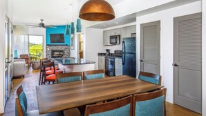A modern kitchen with a central island, built-in appliances, and a dining area with a wooden table and chairs. - WorldMark Scottsdale - 2 Bedroom Accessible (Scottsdale)