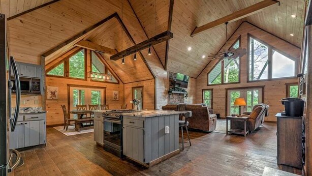 A spacious cabin with a large kitchen, dining area, and multiple windows offering natural light.