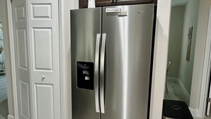 A stainless steel refrigerator with a freezer compartment, a built-in ice maker, and a water dispenser.