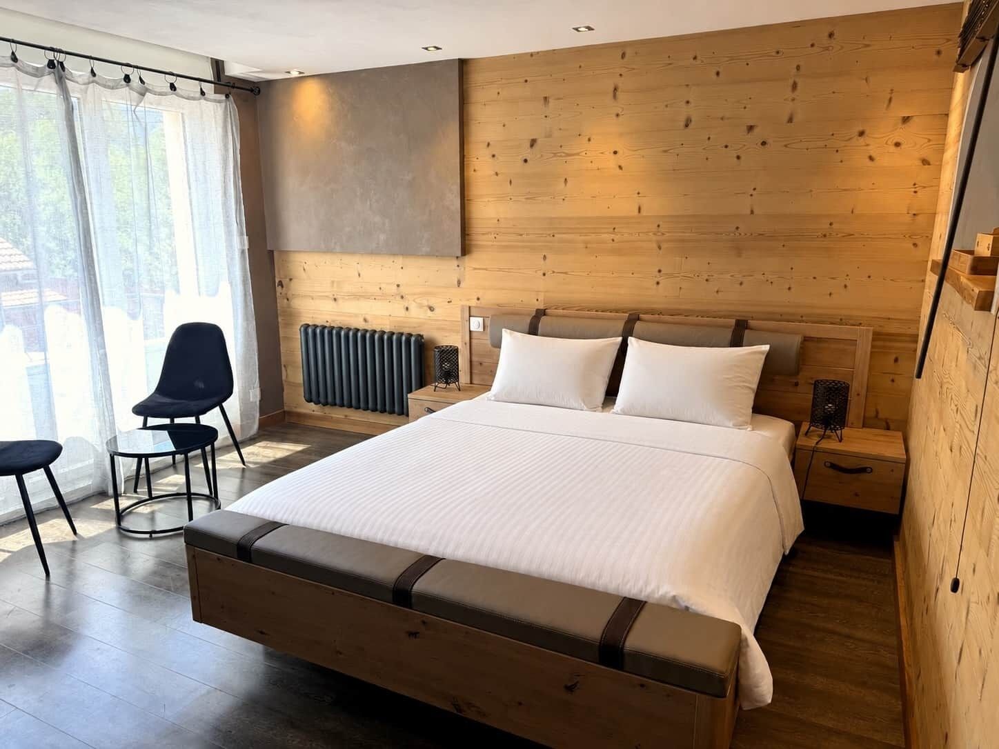 Ein modernes Schlafzimmer mit einem großen Bett, einem Holzkopfende und einer Heizkörper.