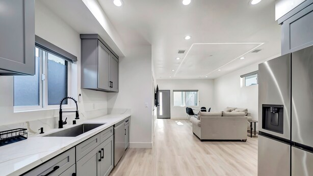 A modern kitchen with a central island, built-in appliances, and a minimalist design.
